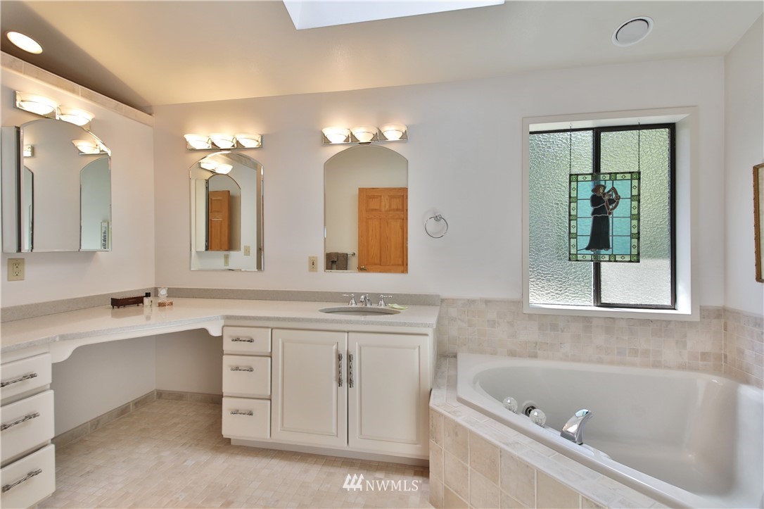 6188 Double Bluff Road Freeland, WA 98249 - Photo 31 of 40 a bathroom with a tub a sink and a window