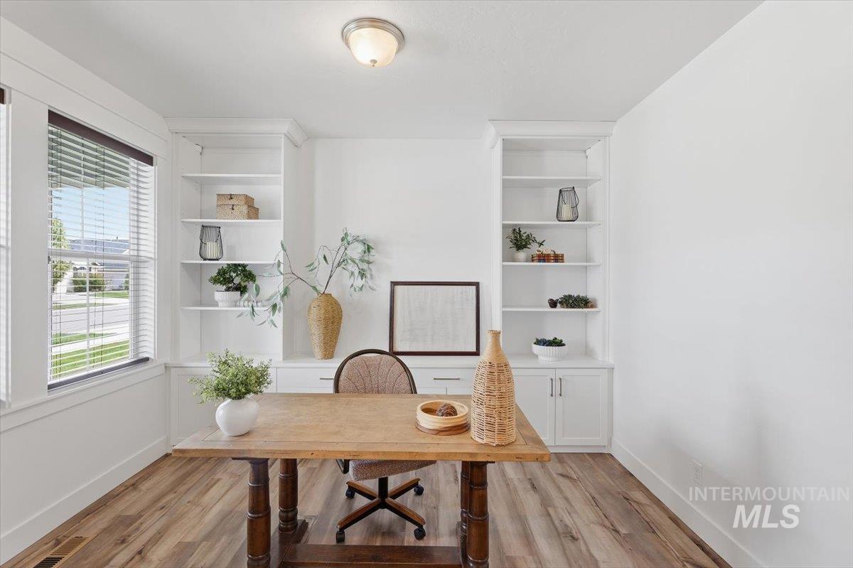 5897 West Riva Capri Street Meridian, ID 83646 - Photo 23 of 50 Light-filled interior space featuring wood-finish flooring, built-in shelving, white baseboards, and a semi-flush mount ceiling light fixture