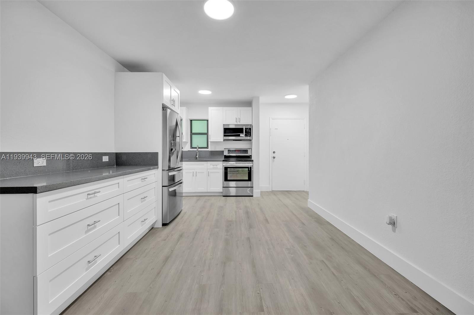 1530 Southwest 2nd Street, Unit 301 Miami, FL 33135 - Photo 7 of 12 a view of a kitchen with wooden floor electronic appliances and cabinets