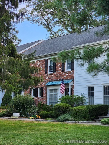 a front view of a house with a yard and potted plants