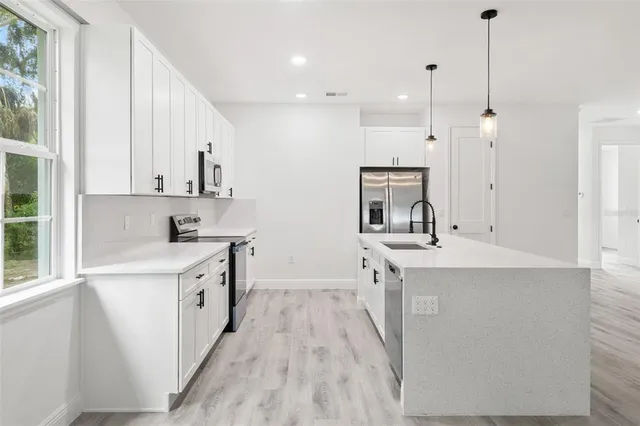 a kitchen with stainless steel appliances granite countertop a sink stove and refrigerator