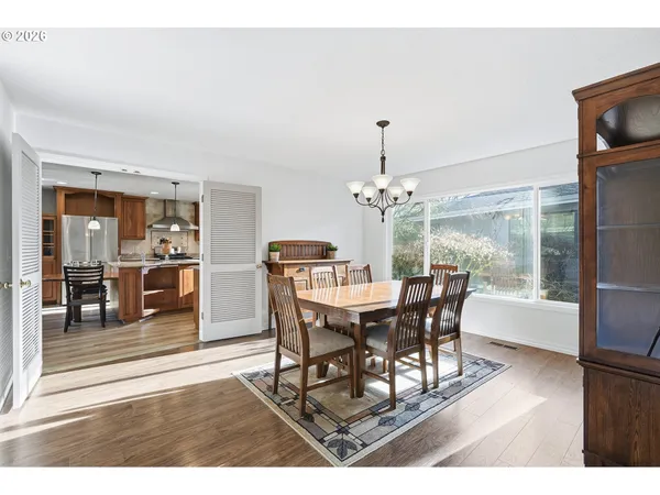 a dining room with furniture a chandelier and wooden floor