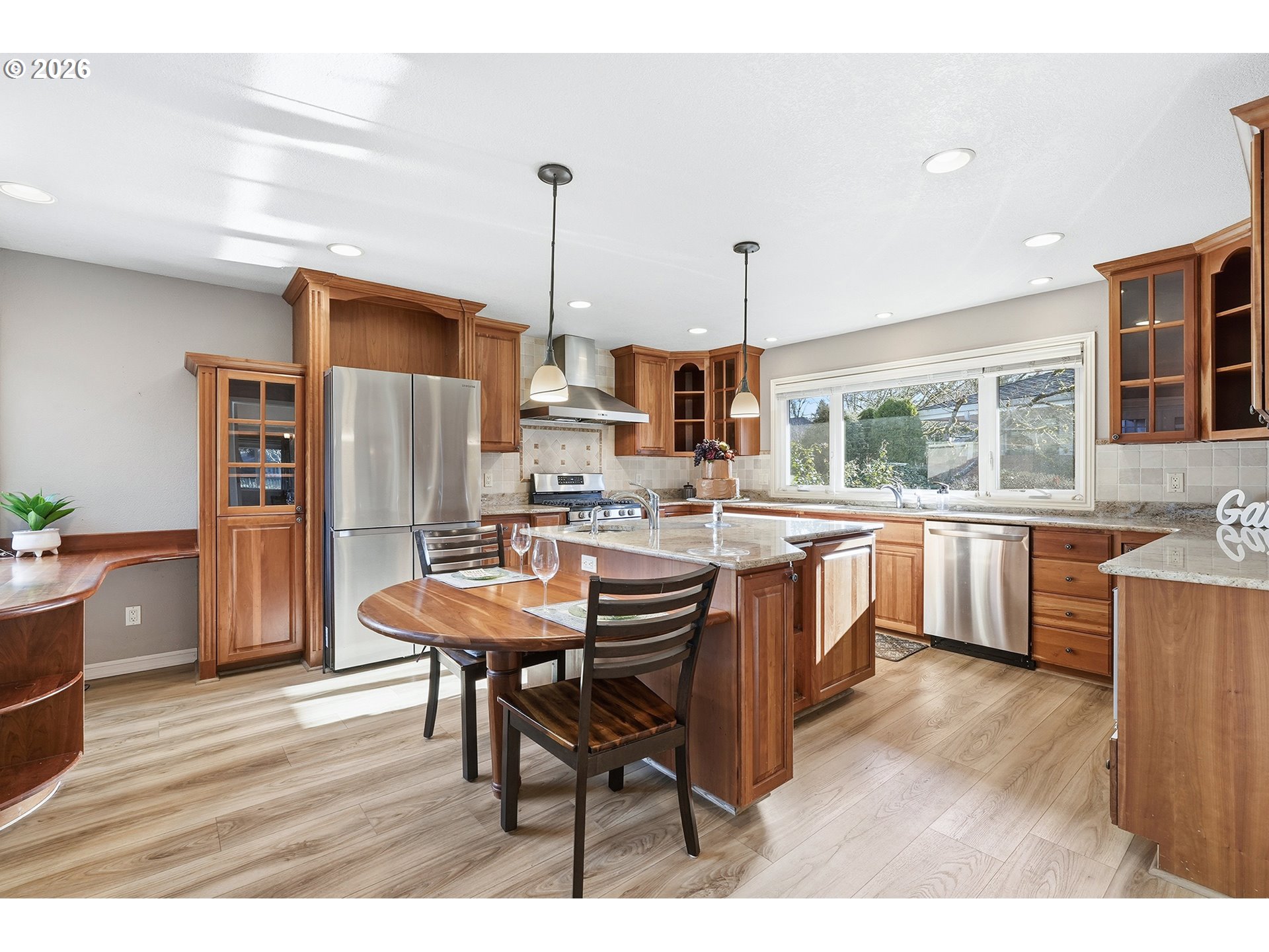 32565 Southwest Lake Point Court Wilsonville, OR 97070 - Photo 18 of 48 a kitchen with stainless steel appliances kitchen island a table chairs in it and wooden floors