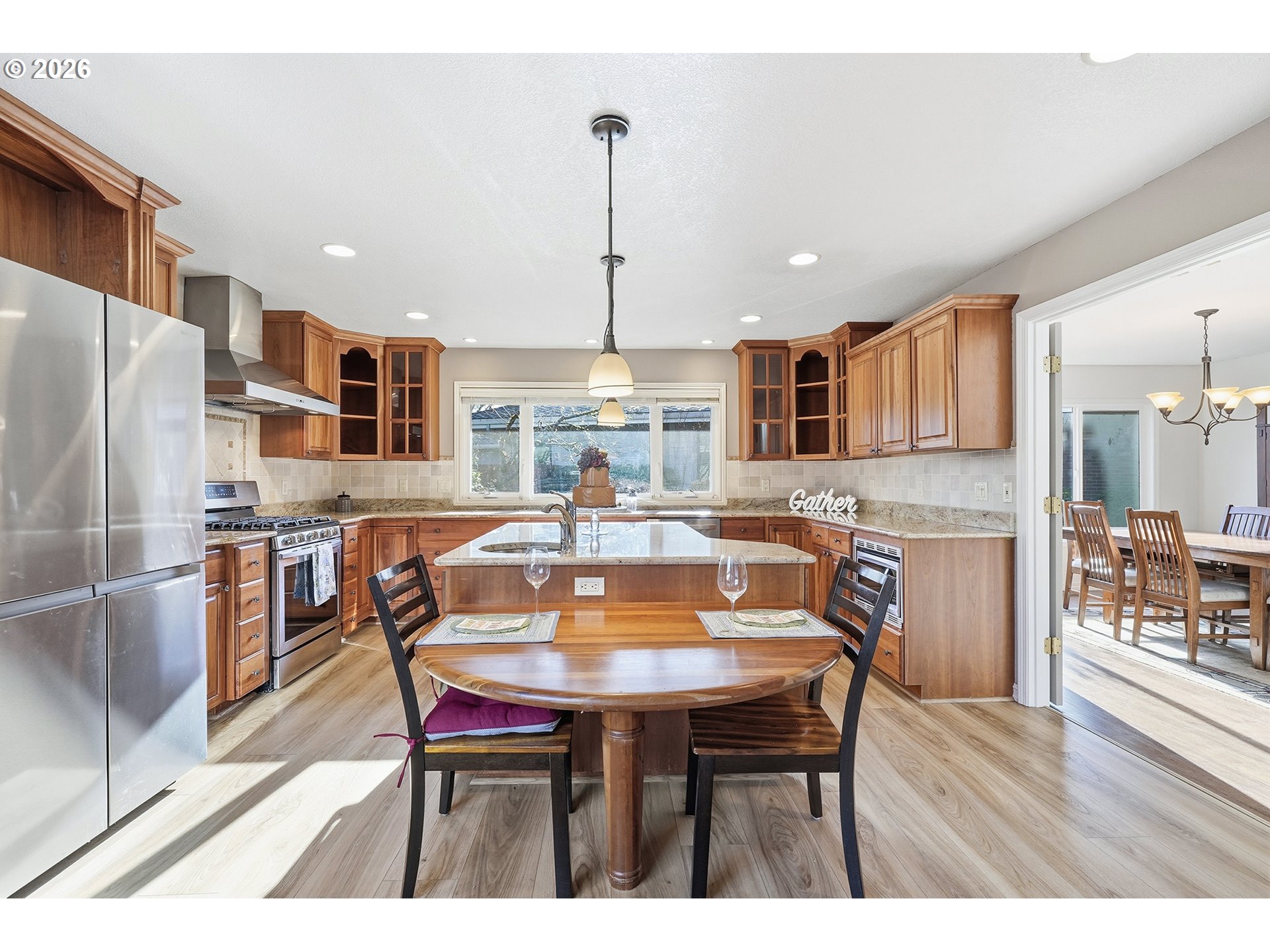 32565 Southwest Lake Point Court Wilsonville, OR 97070 - Photo 22 of 48 a kitchen with stainless steel appliances granite countertop a dining table chairs refrigerator and microwave
