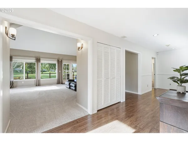 a living room with furniture and a dining table with wooden floor