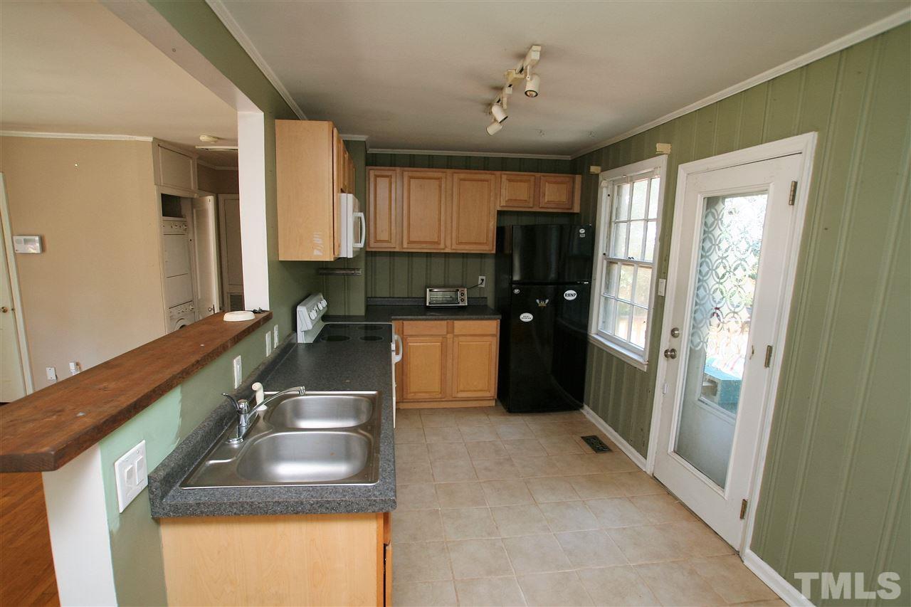 705 Mial Street Raleigh, NC 27608 - Photo 3 of 14 a kitchen with kitchen island granite countertop a sink a counter top space appliances and cabinets