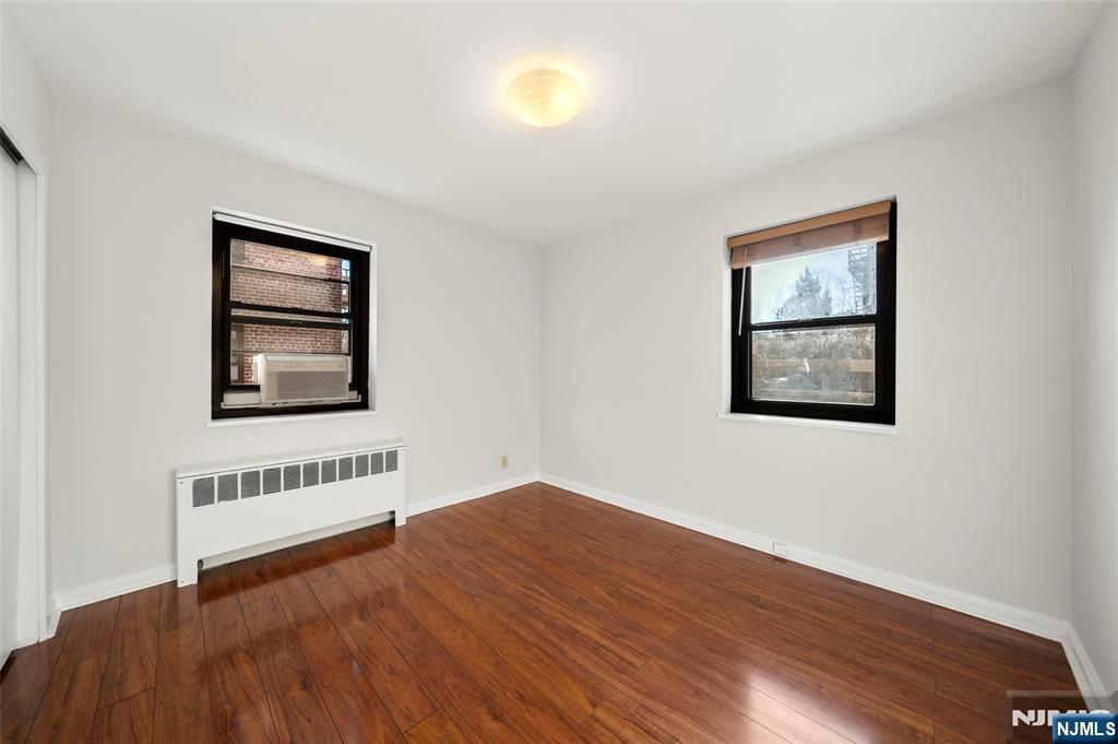 2337 Hudson Terrace, Unit C11 Fort Lee, NJ 07024 - Photo 12 of 23 a view of an empty room with wooden floor and a window