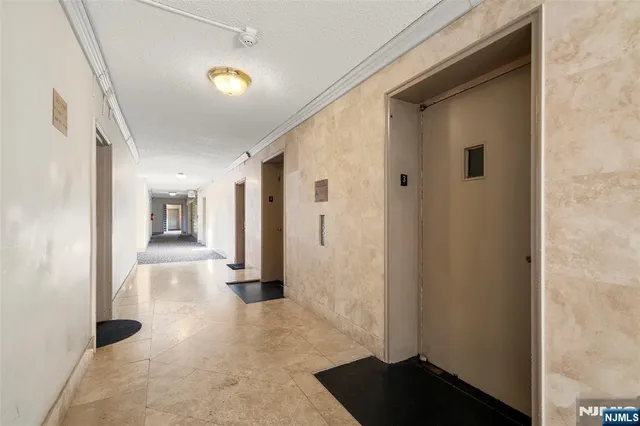 a utility room with dryer washer and a view of living room