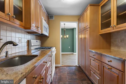 a kitchen with a sink stove top oven and cabinets
