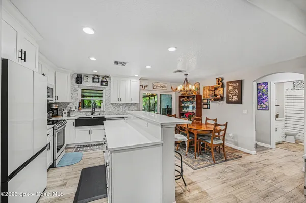 a kitchen with stainless steel appliances kitchen island granite countertop a refrigerator and a stove top oven
