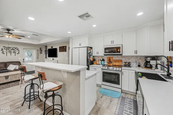 a kitchen with cabinets and chairs