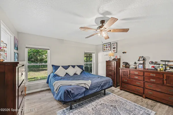 a bedroom with a large bed and a chandelier