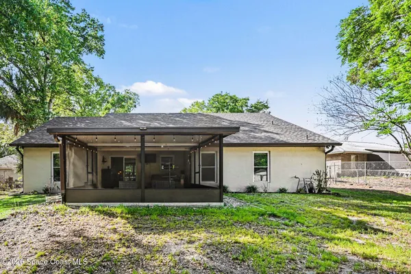 a view of a backyard with table and chairs and a large tree