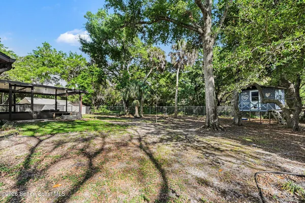 a view of a house with backyard and trees