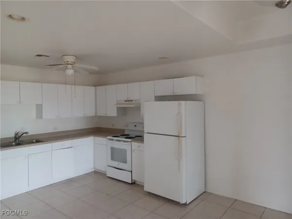 a kitchen with white cabinets and white appliances