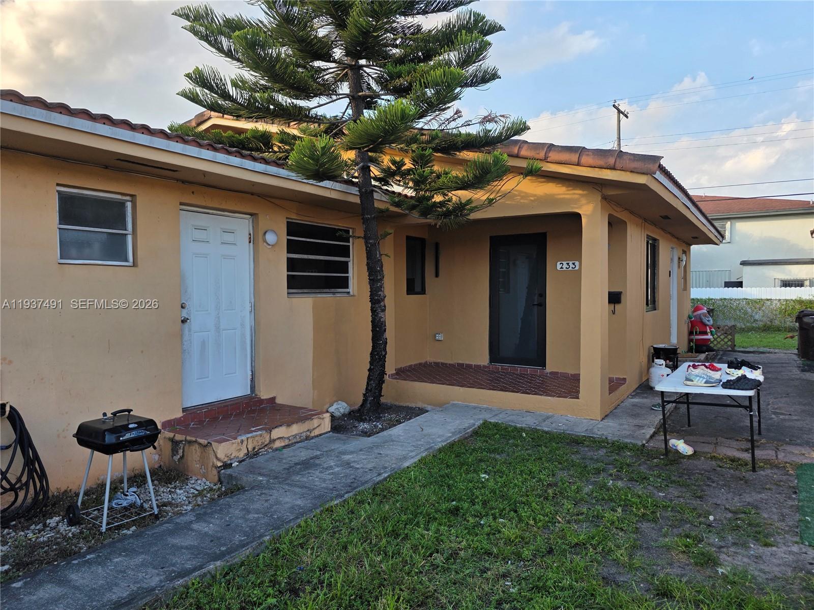 233 East 7th Street, Unit 2 Hialeah, FL 33010 - Photo 2 of 12 a backyard of a house with table and chairs