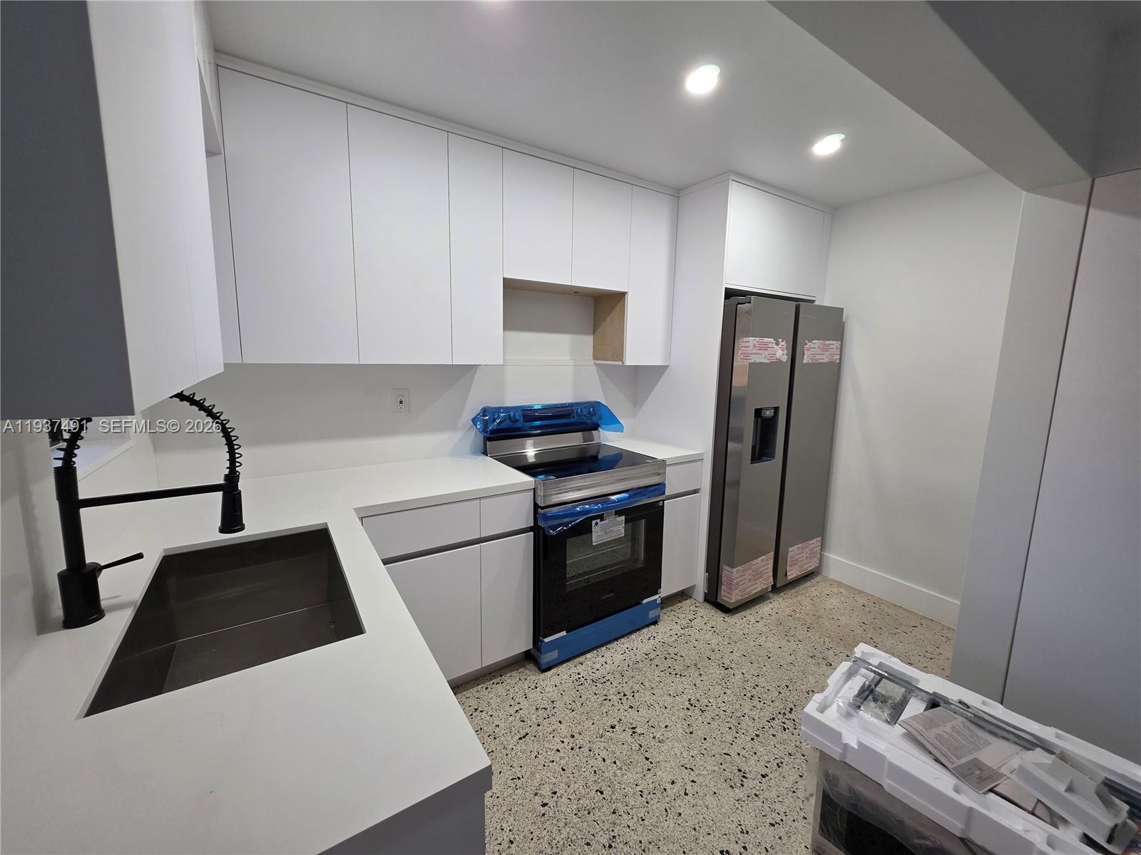233 East 7th Street, Unit 2 Hialeah, FL 33010 - Photo 4 of 12 a kitchen with a refrigerator sink and stove