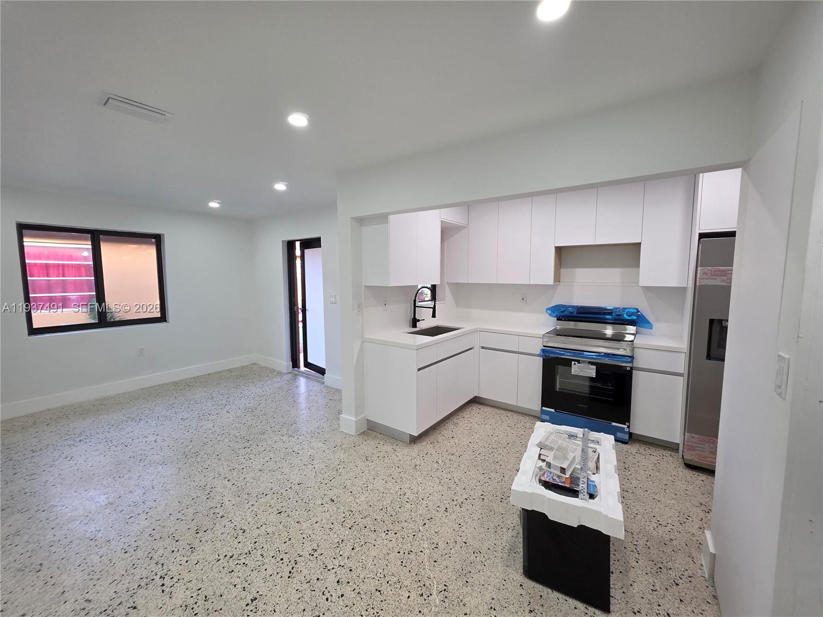 233 East 7th Street, Unit 2 Hialeah, FL 33010 - Photo 5 of 12 a kitchen with stainless steel appliances kitchen island granite countertop a sink stove and refrigerator