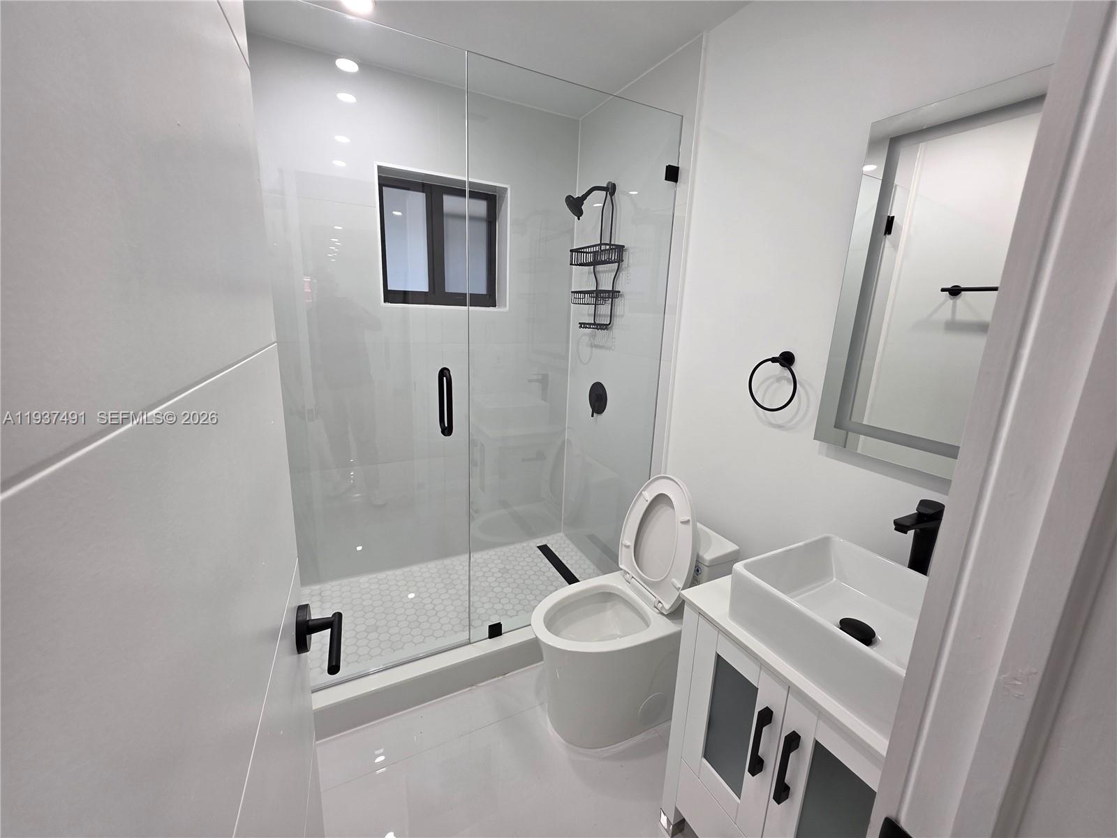 233 East 7th Street, Unit 2 Hialeah, FL 33010 - Photo 6 of 12 a bathroom with a sink mirror vanity and toilet