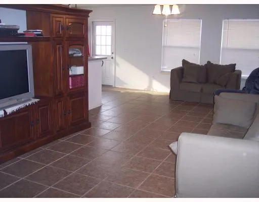 a living room with furniture a flat screen tv and entryway