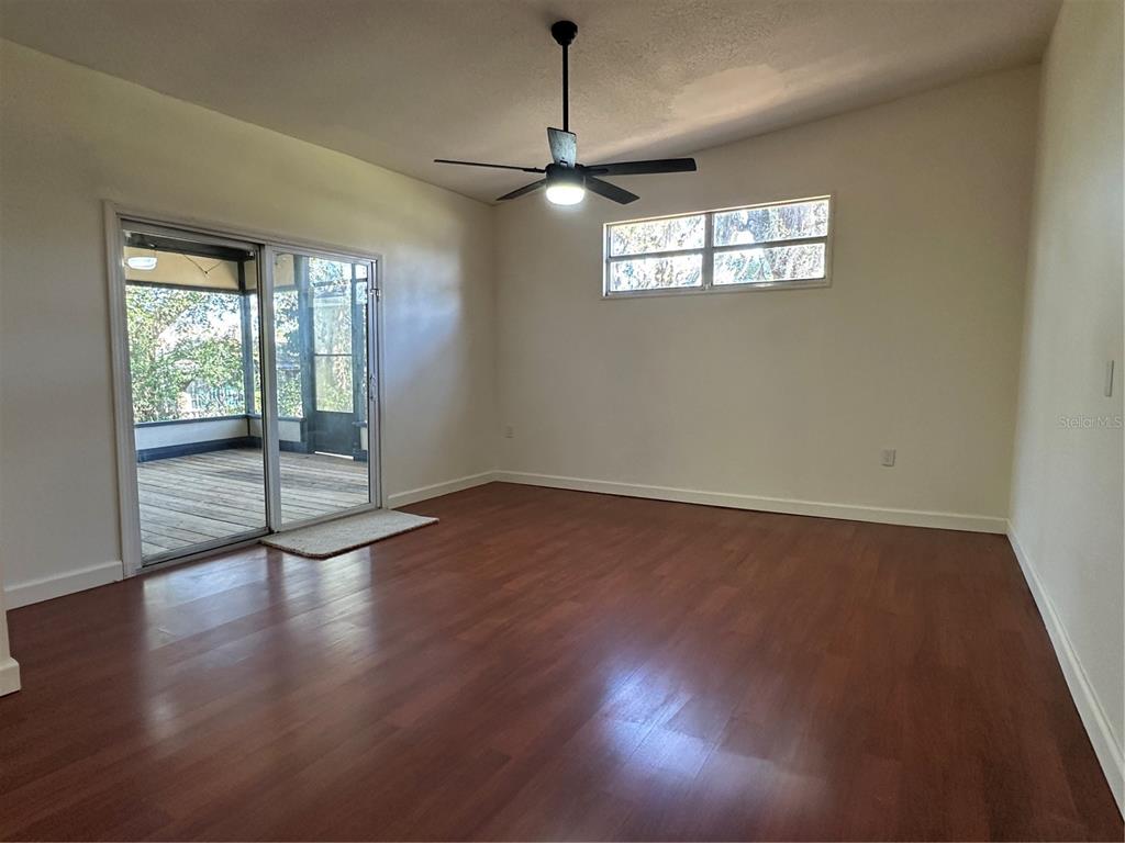 627 Prairie Lane Altamonte Springs, FL 32714 - Photo 14 of 32 a view of an empty room with wooden floor and a window