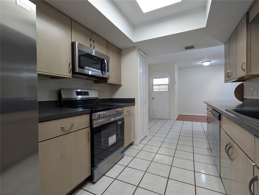627 Prairie Lane Altamonte Springs, FL 32714 - Photo 7 of 32 a kitchen with stainless steel appliances granite countertop a stove a sink and a microwave
