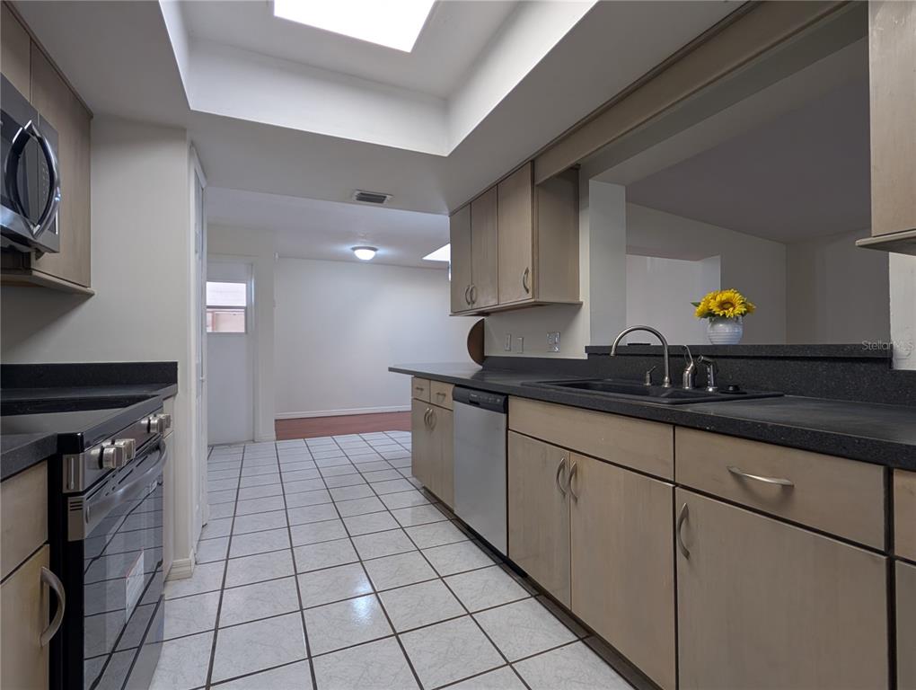 627 Prairie Lane Altamonte Springs, FL 32714 - Photo 8 of 32 a kitchen with granite countertop a sink a stove and cabinets