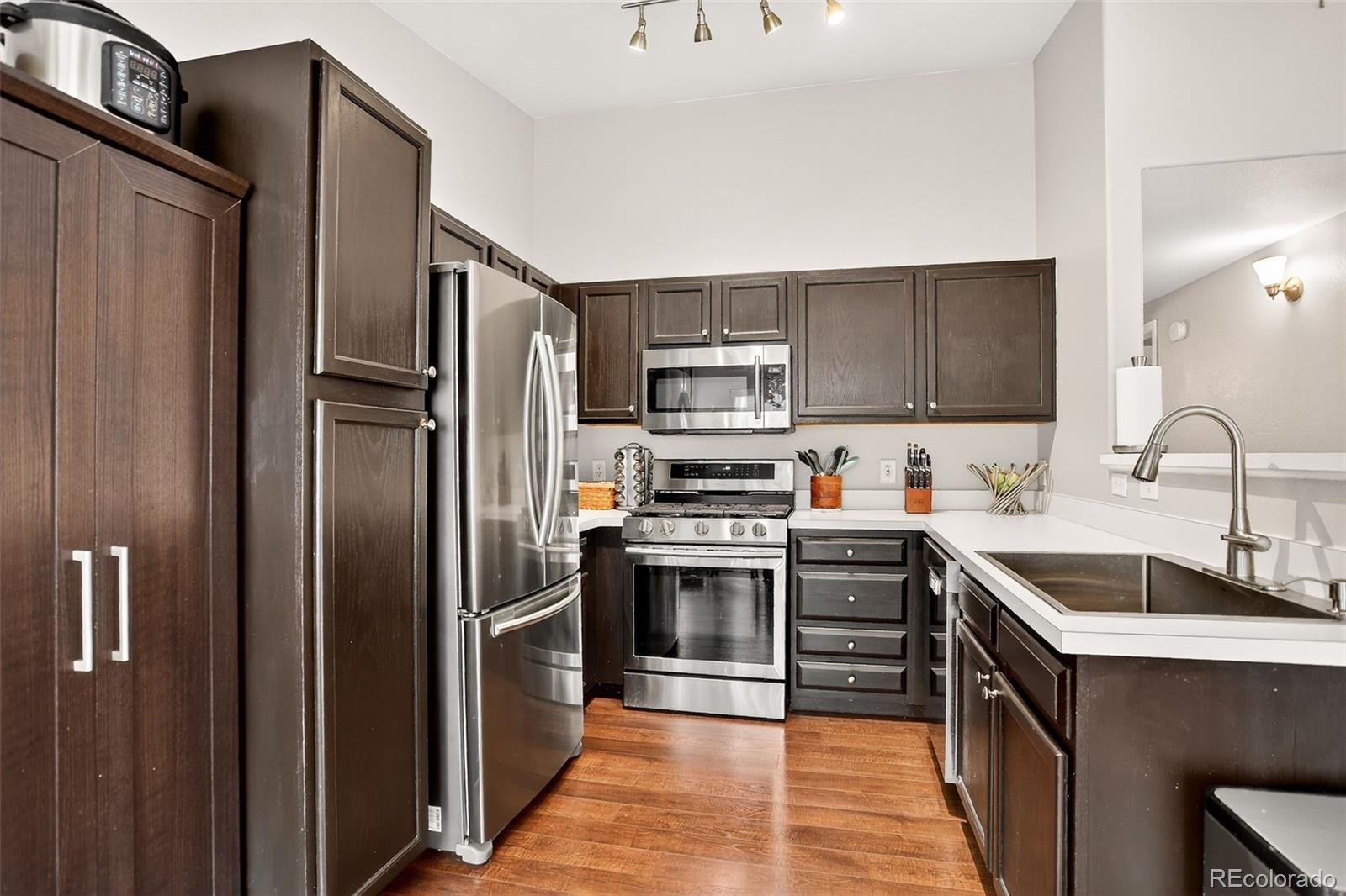 8415 Pebble Creek Way, Unit 203 Highlands Ranch, CO 80126 - Photo 11 of 36 a kitchen with stainless steel appliances granite countertop a refrigerator stove and sink