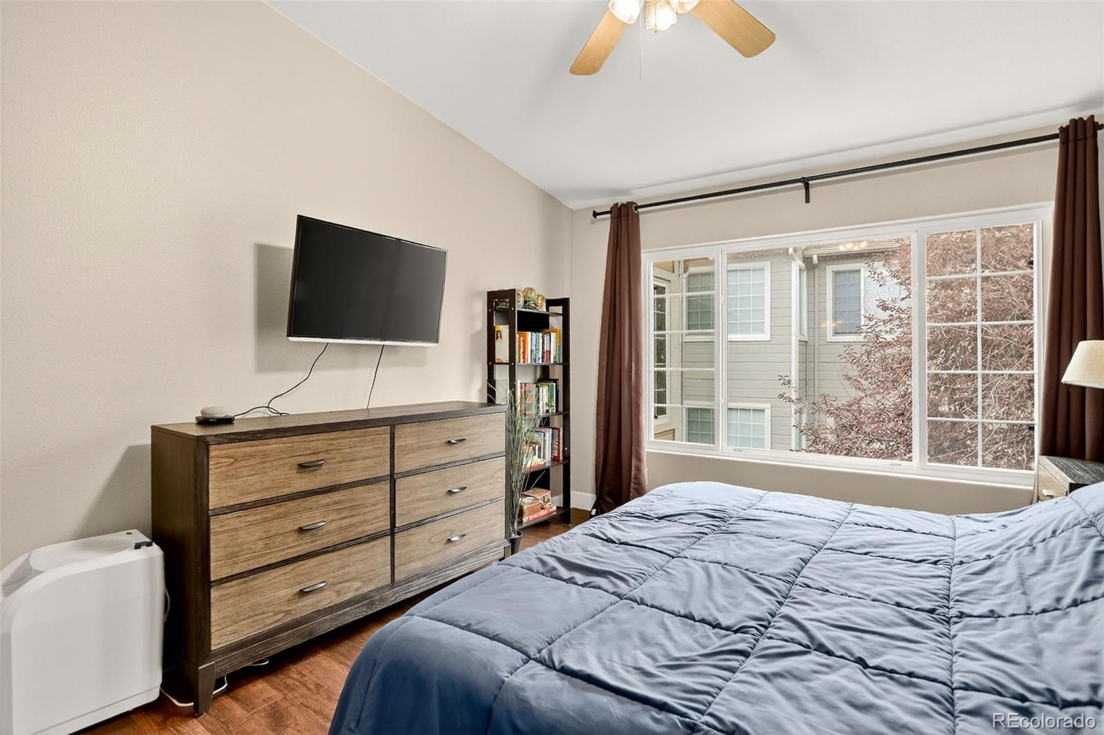8415 Pebble Creek Way, Unit 203 Highlands Ranch, CO 80126 - Photo 15 of 36 a bedroom with a bed and a flat screen tv