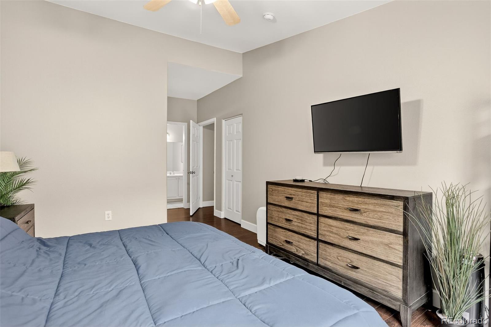8415 Pebble Creek Way, Unit 203 Highlands Ranch, CO 80126 - Photo 16 of 36 a bedroom with a bed and a flat screen tv