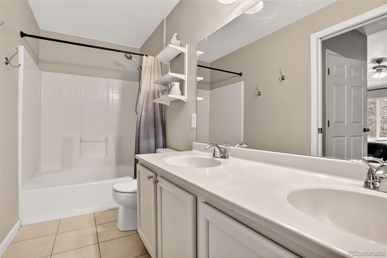 8415 Pebble Creek Way, Unit 203 Highlands Ranch, CO 80126 - Photo 18 of 36 a bathroom with a sink toilet double vanity and shower