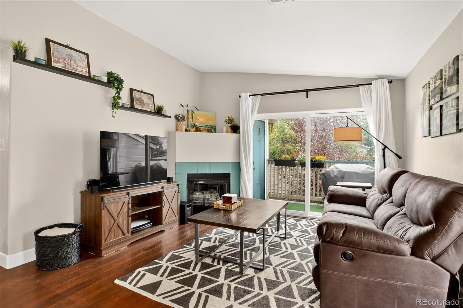 8415 Pebble Creek Way, Unit 203 Highlands Ranch, CO 80126 - Photo 6 of 36 a living room with furniture a flat screen tv and a fireplace