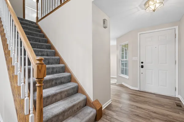 a view of a hallway with wooden floor and entryway