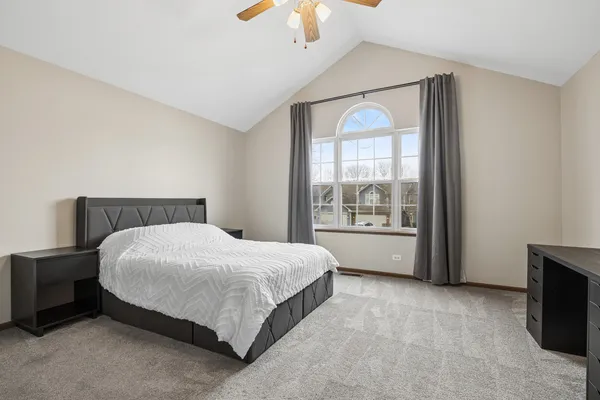 a large bed sitting in a bedroom next to a window