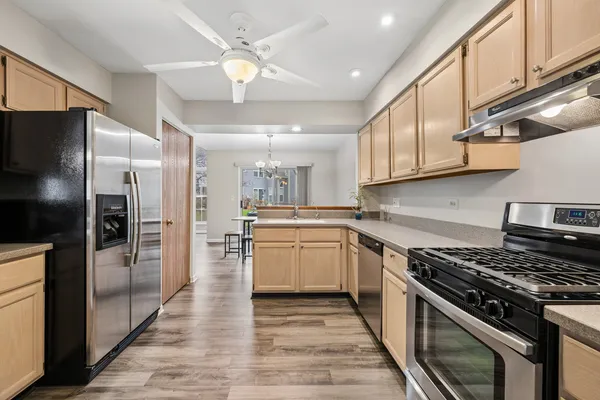 a kitchen with stainless steel appliances granite countertop a stove and a refrigerator
