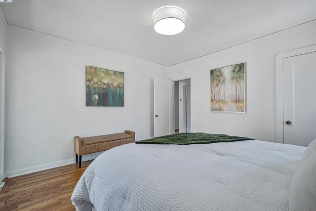 a bedroom with a bed and a painting on the wall