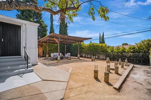 a view of a patio with a table and chairs under an umbrella