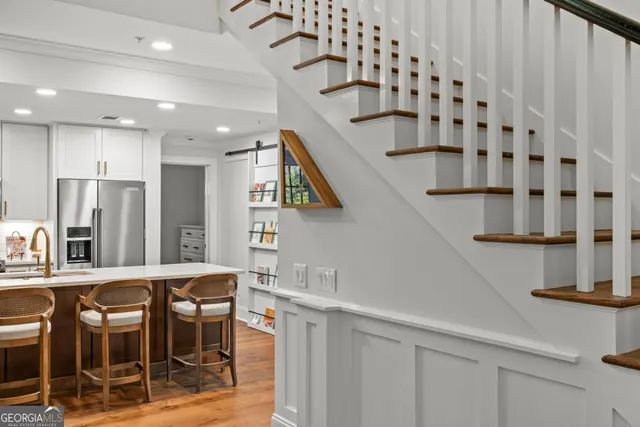 a kitchen with stainless steel appliances kitchen island granite countertop a refrigerator and a sink
