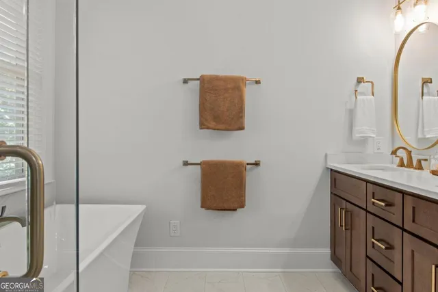 a bathroom with a tub sink and mirror