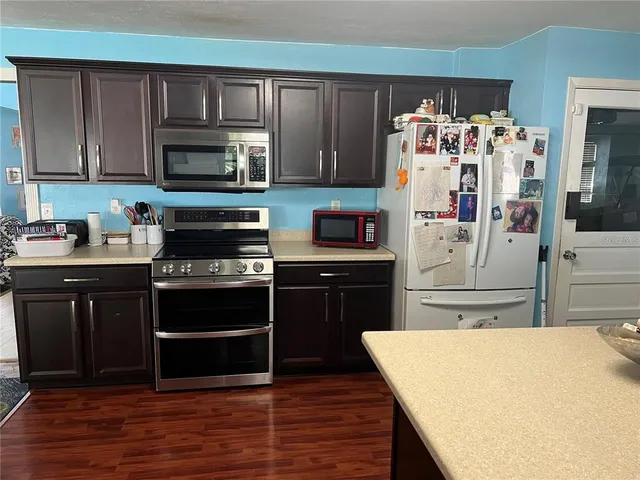 a kitchen with stainless steel appliances a stove a refrigerator and cabinets