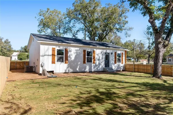 a view of a house with a big yard and large tree