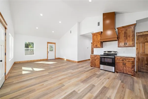 a kitchen with stainless steel appliances granite countertop a sink and wooden floor