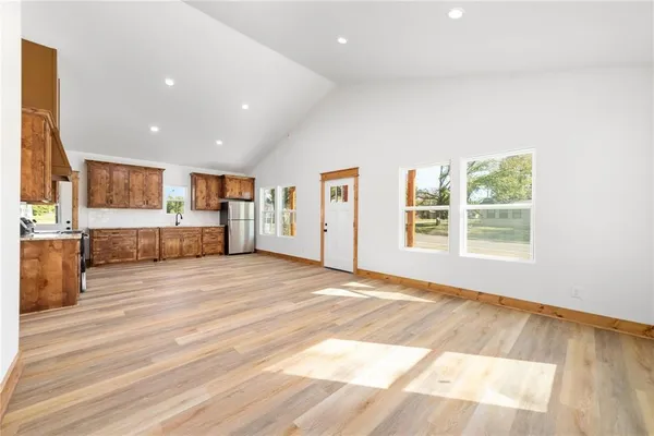 a view of an empty room with kitchen appliances and a window