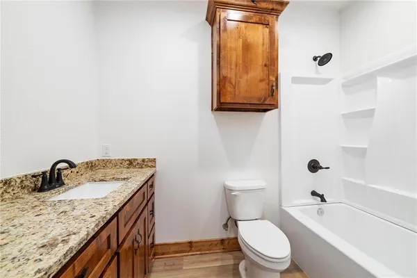 a bathroom with a granite countertop sink mirror vanity and toilet