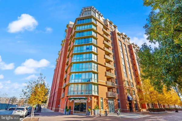 a front view of multi story residential apartment building with yard and parking space