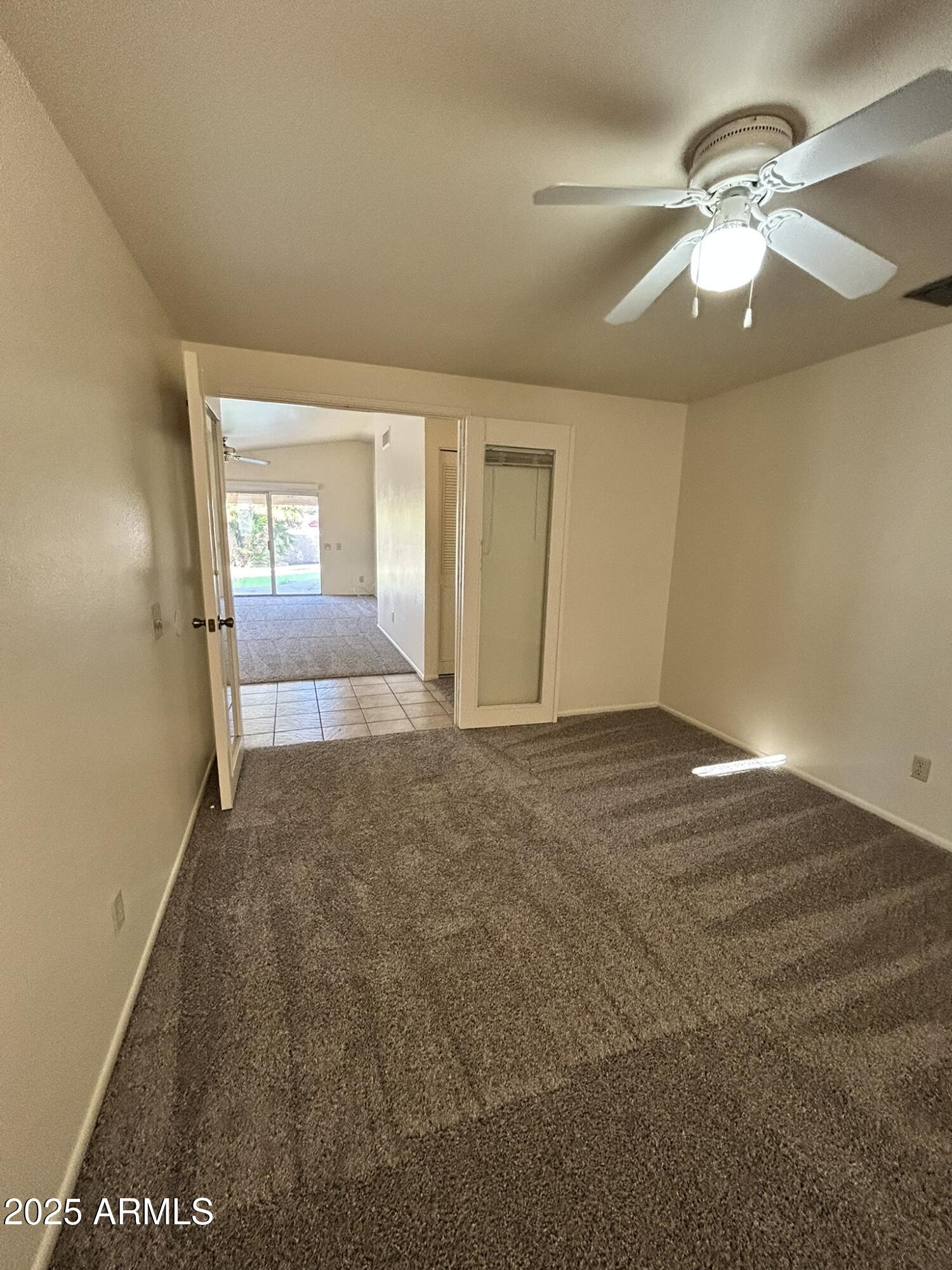 2120 North Yucca Court Chandler, AZ 85224 - Photo 18 of 32 an empty room with a chandelier fan and windows