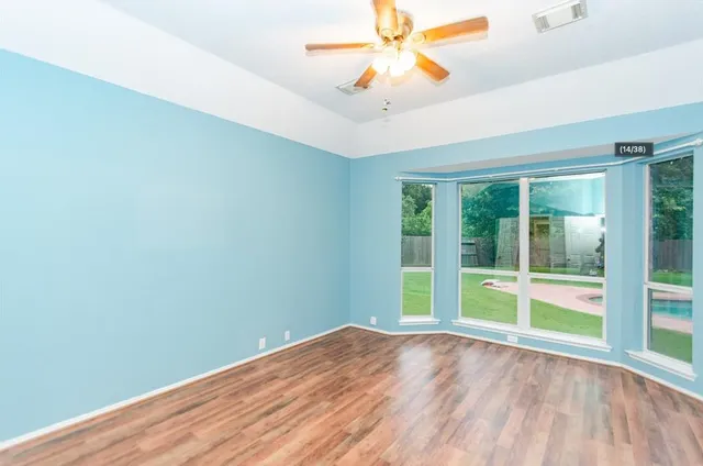 wooden floor in an empty room with a window