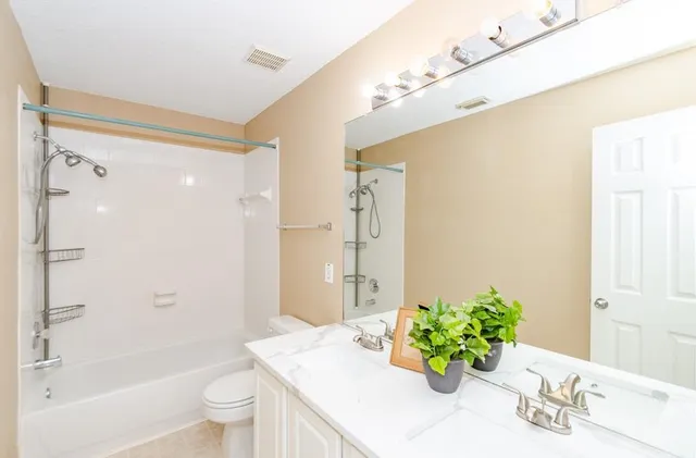 a bathroom with a bathtub shower sink and toilet