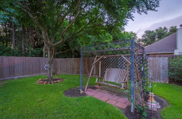 a backyard of a house with trampoline and wooden fence