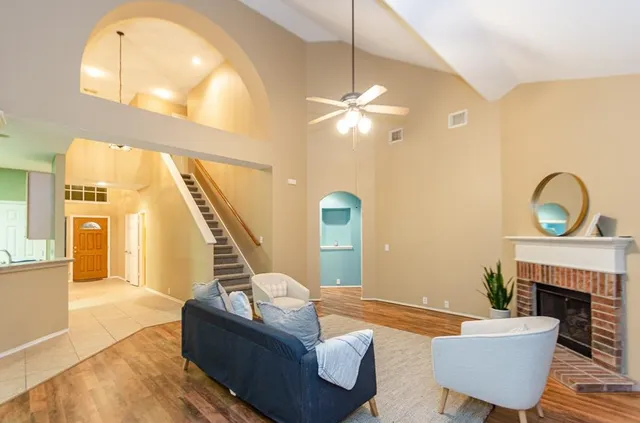 a living room with furniture a fireplace and a large window